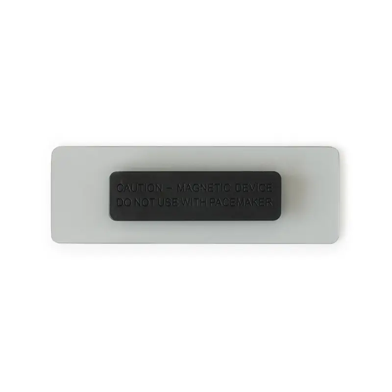 Reverso de la placa blanca con el agarre magnético negro acoplado al centro, que lleva un texto de advertencia en relieve